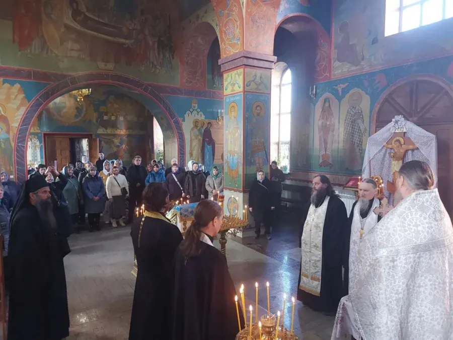 Священнослужители и прихожане собрались в расписанном храме во время молитвы.