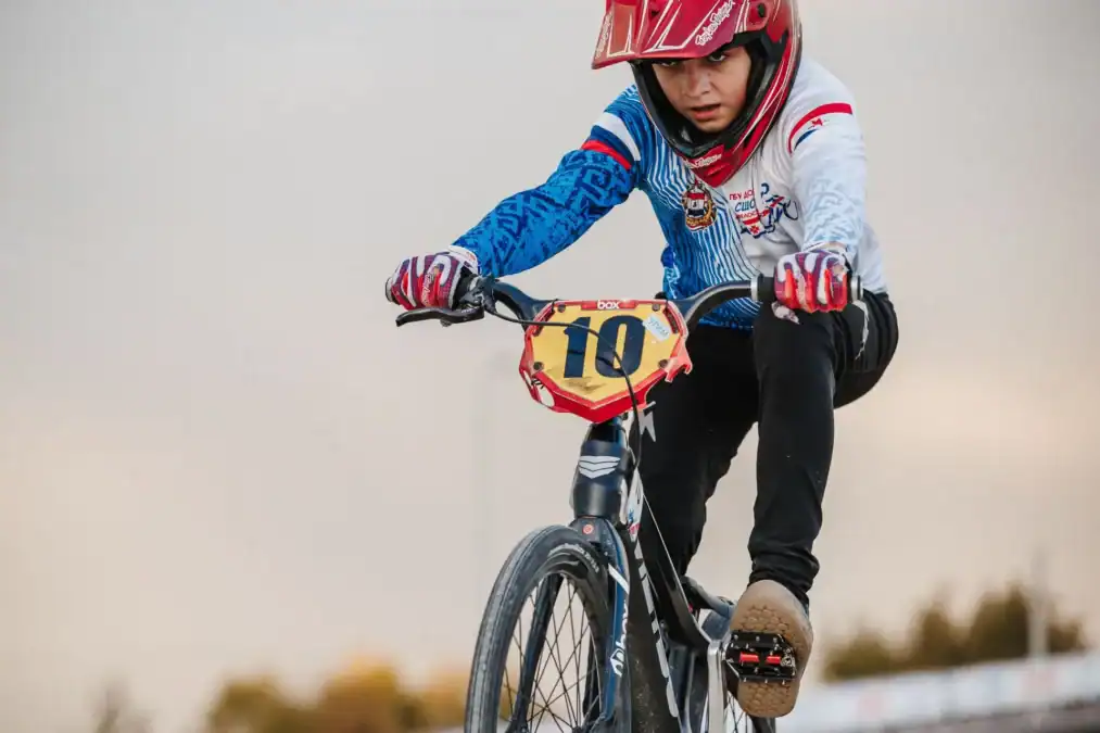 BMX-райдер с номером 10 преодолевает участок трассы.