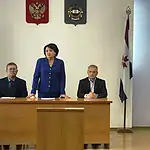 Члены президиума сидят за столами в зале администрации района.