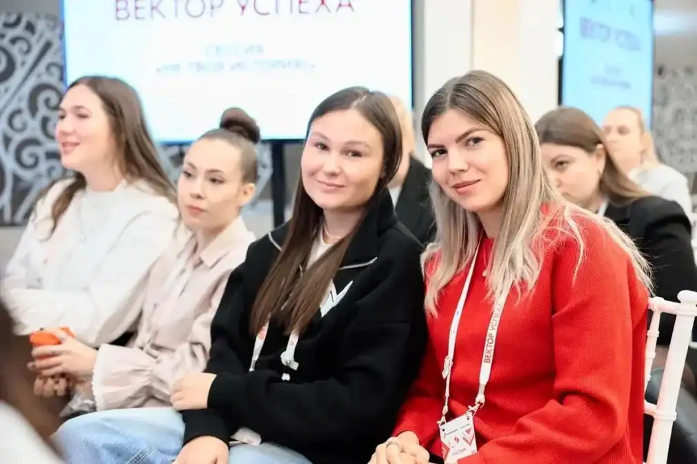 Участницы с бейджами сидят в зале во время семинара.