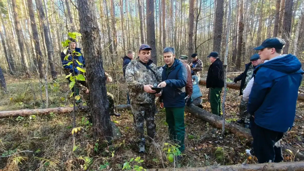 Двое специалистов рассматривают инструмент или образец среди участников обследования.