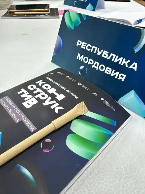 На столе лежат программа форума, деревянный молоток и табличка «Республика Мордовия».