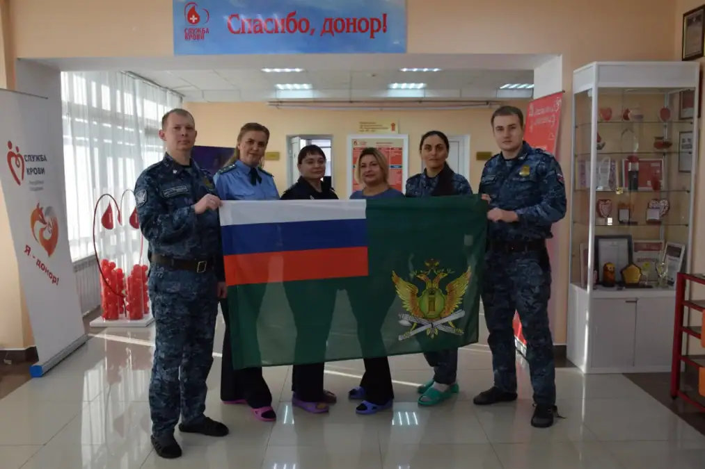 Шесть человек в форме и медицинской одежде держат флаги в центре крови.