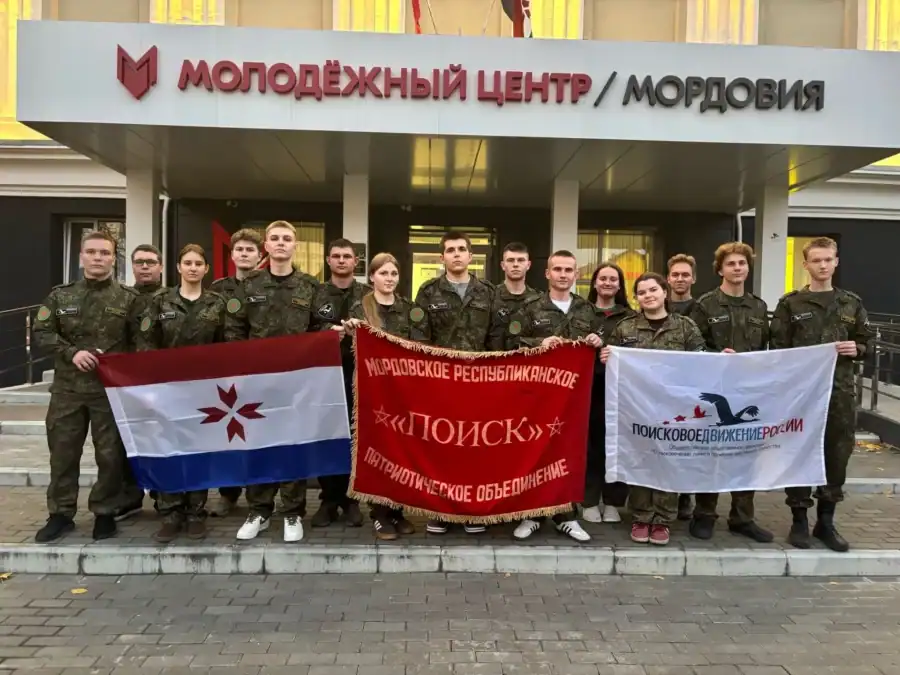 Участники поисковых отрядов с флагами стоят у Молодёжного центра Мордовии.