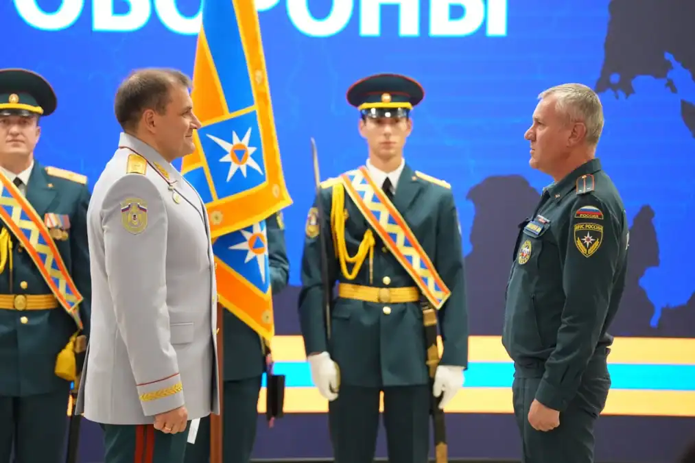 Два офицера в парадной форме стоят перед почётным караулом и знаменем.
