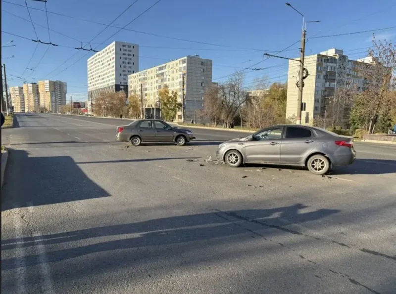 Два седана остановились на дороге, между ними лежат обломки автомобилей.