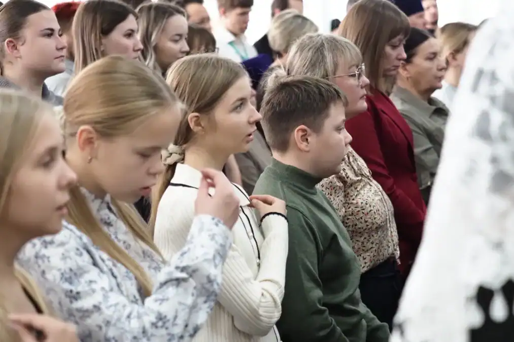 Участники форума разных возрастов сидят в зале и слушают выступление.