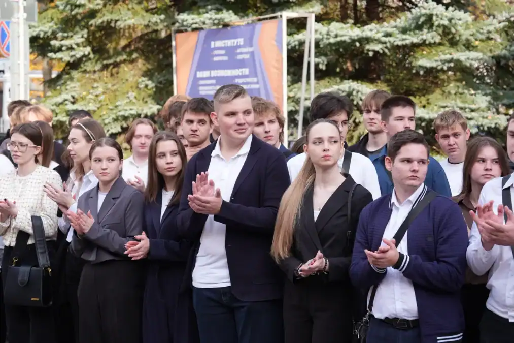 Студенты и молодые люди аплодируют во время уличного мероприятия.
