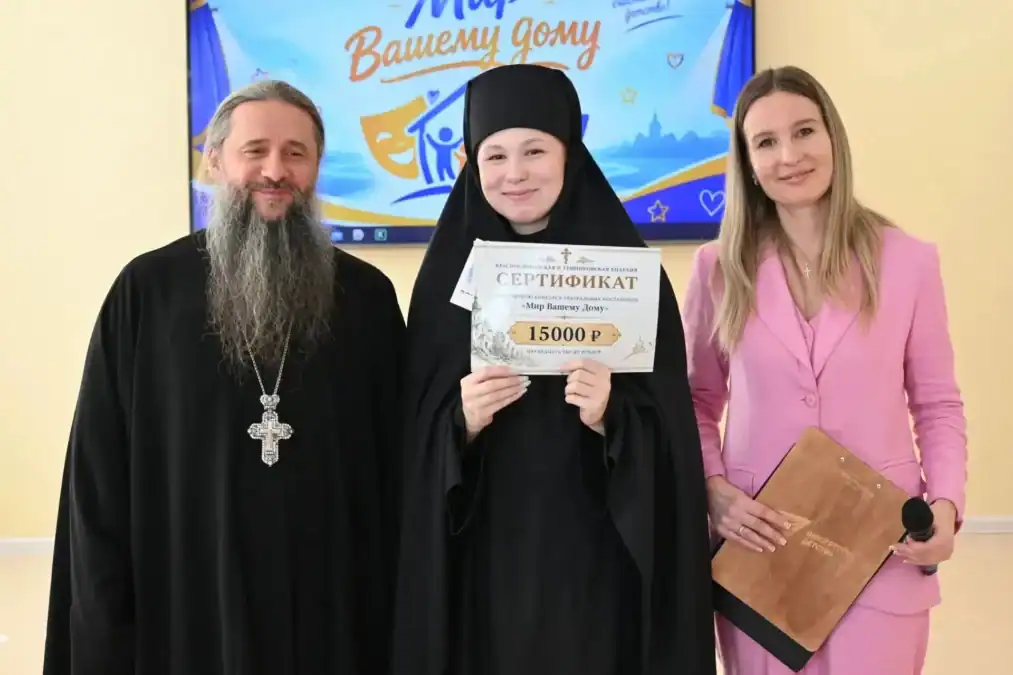 Монахиня держит сертификат на 15 тысяч рублей рядом с двумя взрослыми.