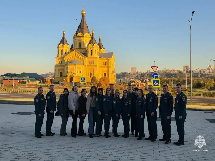 Группа сотрудников МЧС стоит на площади перед большим православным храмом.
