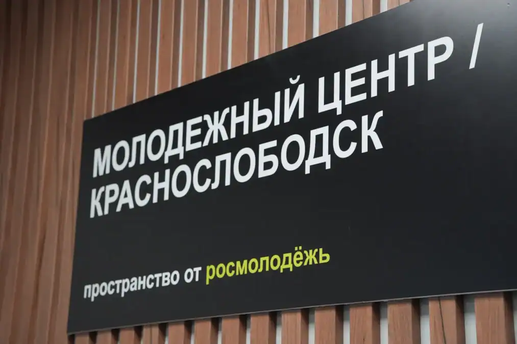 Вывеска молодежного центра «Краснослободск» на деревянной стене.