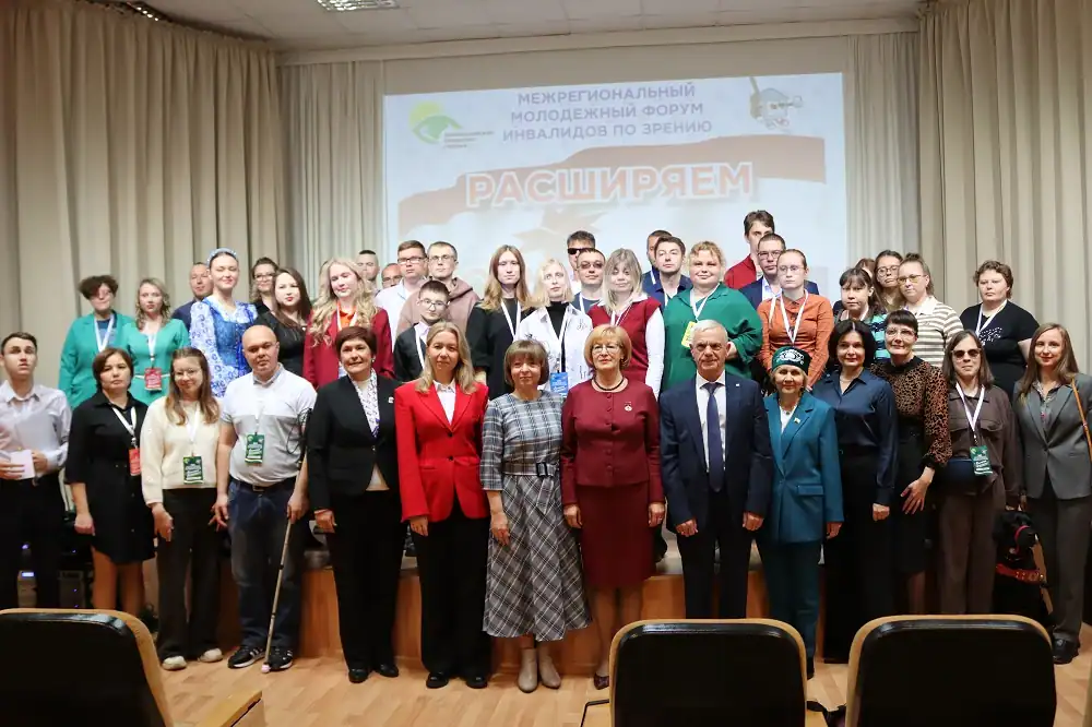 Участники и организаторы форума позируют для общего снимка на сцене.