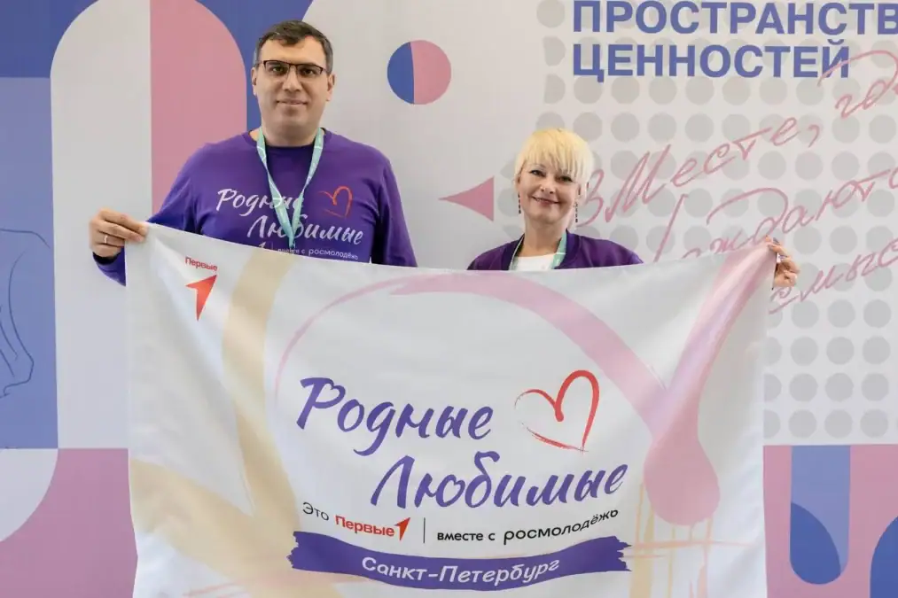 Двое участников держат флаг сообщества «Родные — Любимые».