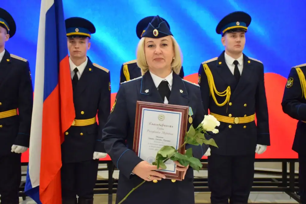 Сотрудница в парадной форме держит грамоту и белые розы.