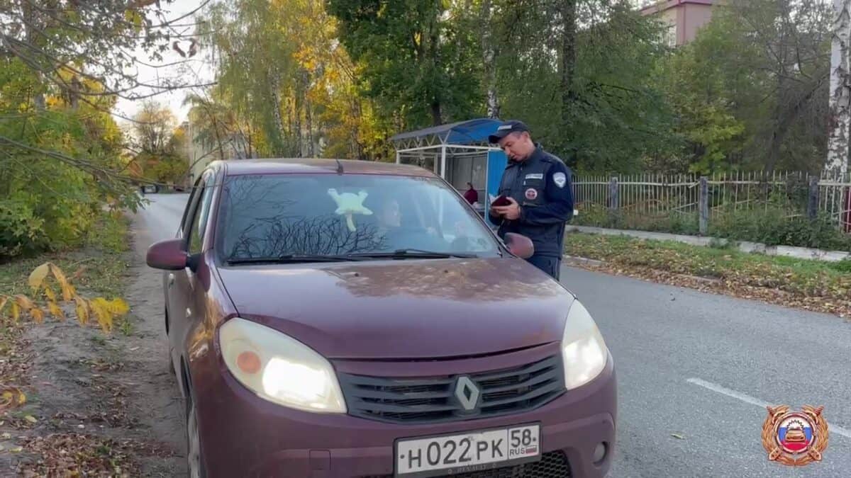 Инспектор ДПС проверяет автомобиль Renault, остановленный у обочины.