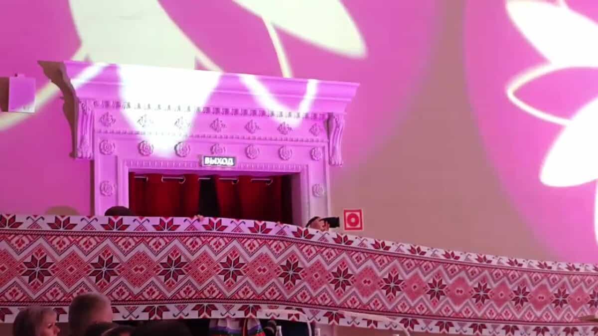 Орнаментированное полотнище протянуто над зрителями в концертном зале.