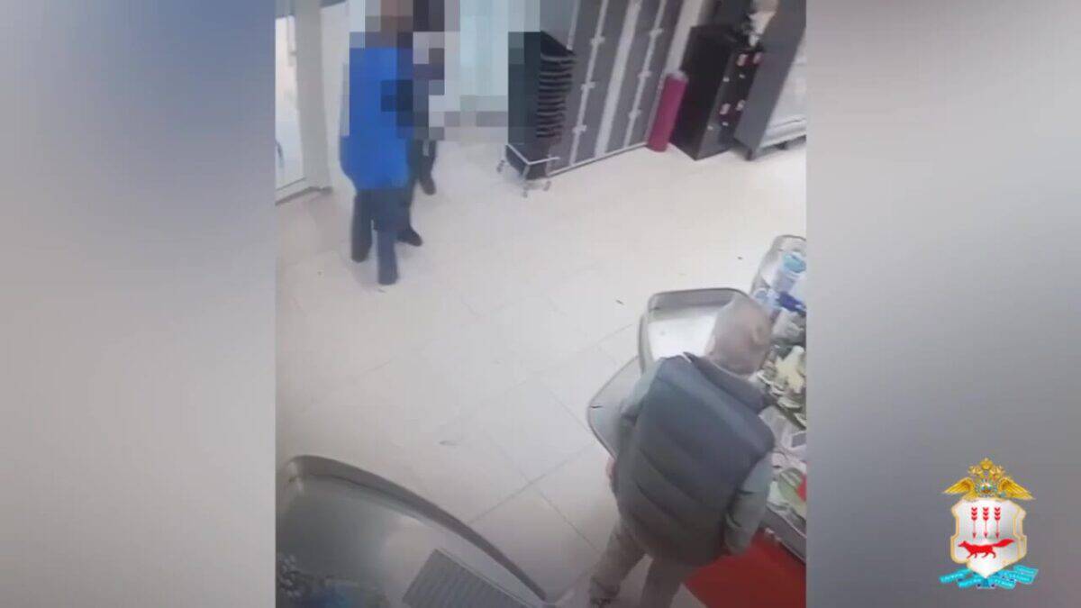 Двое мужчин находятся в торговом помещении у прилавка и стеллажей.