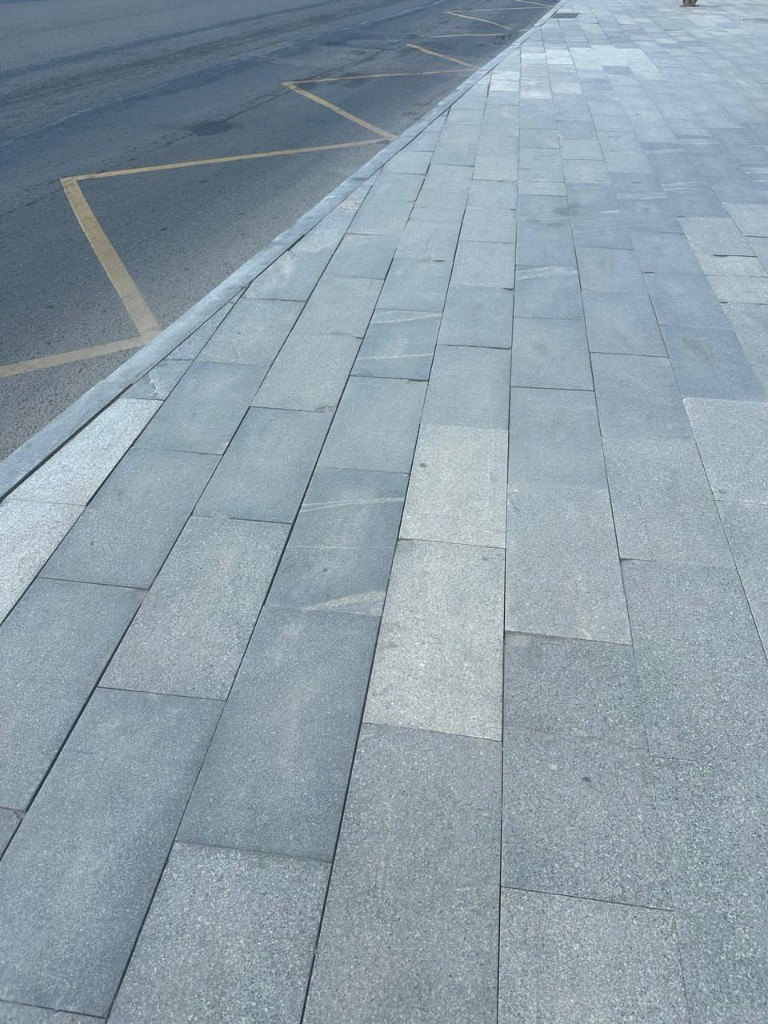 Узкая асфальтированная тропинка с бордюрами в сквере