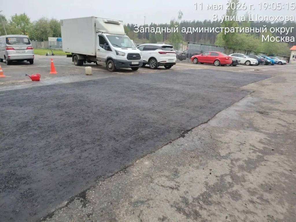 Ночная работа дорожных рабочих по распределению горячего асфальта лопатами