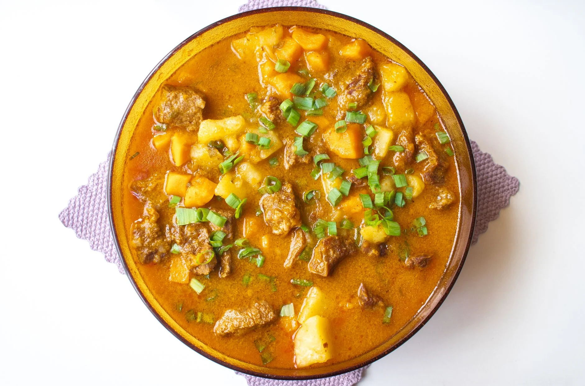 Delicious Brazilian beef stew with potatoes and green onions served in a bowl.