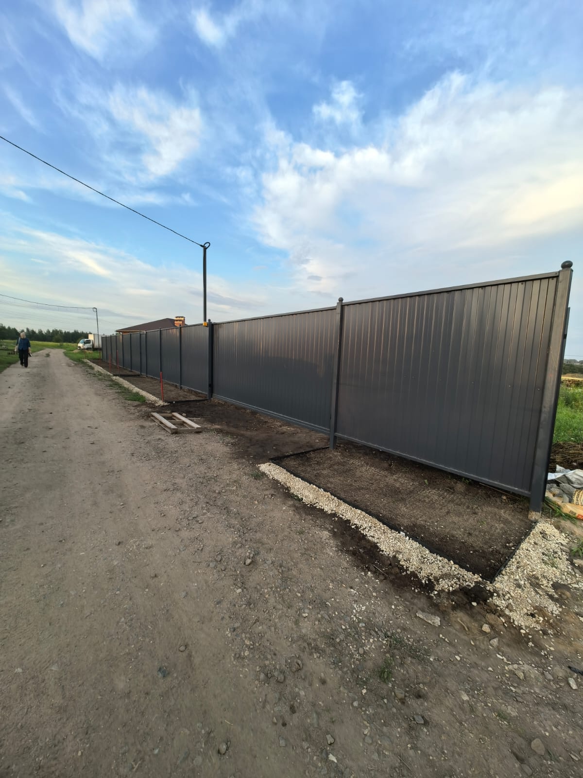 Забор из профнастила серый — ровная линия вдоль дороги